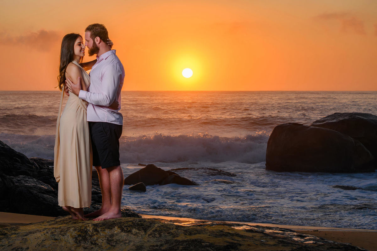 Casal se olhando de frente com ondas ao fundo durante ensaio pré-wedding em Balneário Camboriú