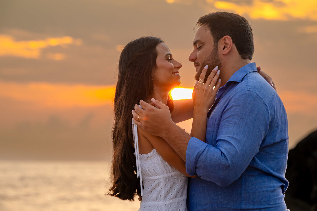 ensaio fotográfico de casal na praia do estaleirinho balneário camboriú casal encostado em grande formação rochosa
