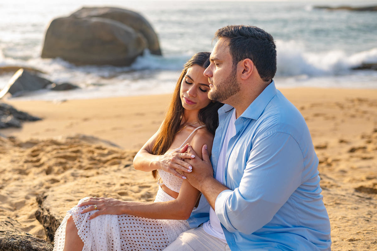 ensaio pré wedding balneário camboriú casal sentado na areia abraçados na praia do estaleirinho