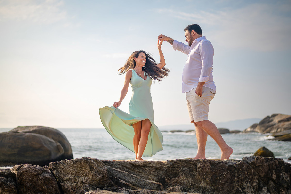 ensaio fotográfico de casal balneário camboriú noivo girando a noiva nas pedras da praia do estaleirinho