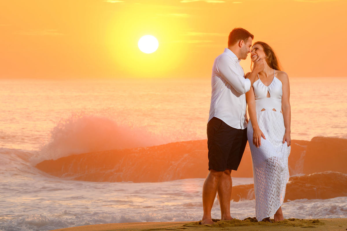 Casal posando em frente ao mar com ondas ao fundo no amanhecer na Praia do Estaleirinho – SC