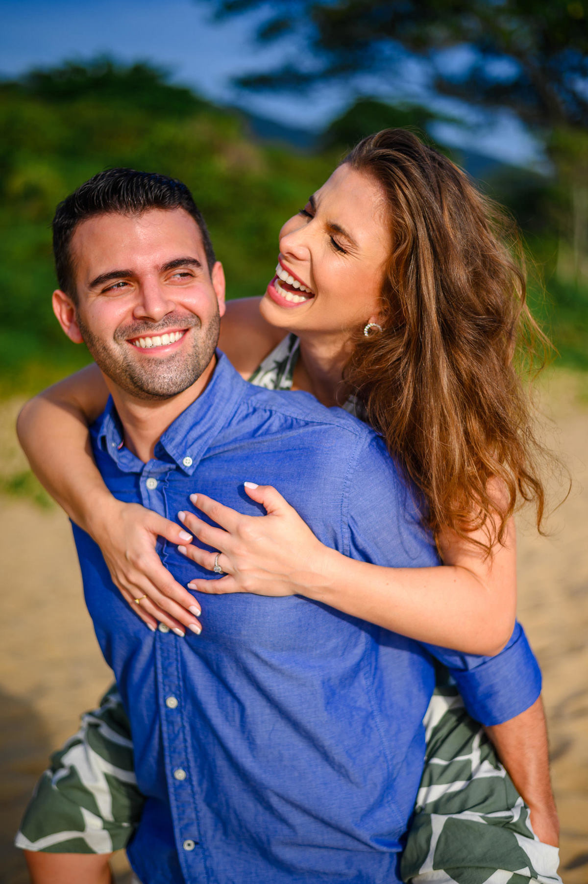 Casal se abraçando com sorriso espontâneo durante ensaio pré-wedding na praia em Santa Catarina