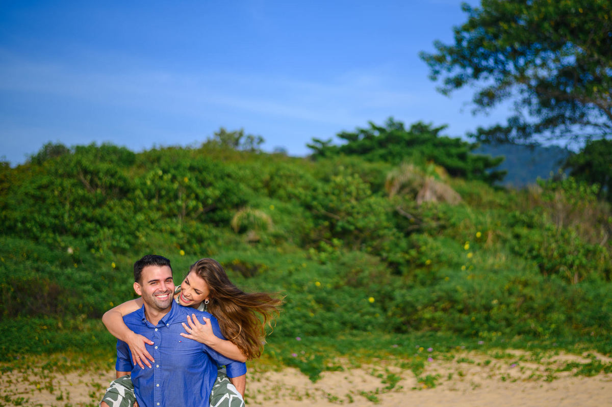 Casal se abraçando com sorriso espontâneo durante ensaio pré-wedding na praia em Santa Catarina