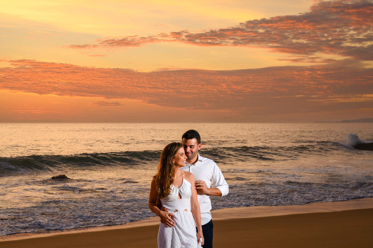 Casal abraçado em frente ao mar ao nascer do sol na Praia do Estaleirinho em Balneário Camboriú – SC