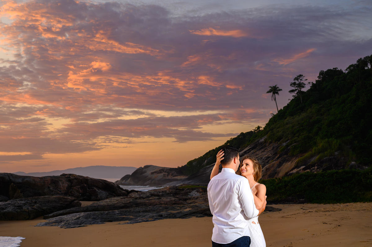 Casal abraçado em frente ao mar ao nascer do sol na Praia do Estaleirinho em Balneário Camboriú – SC
