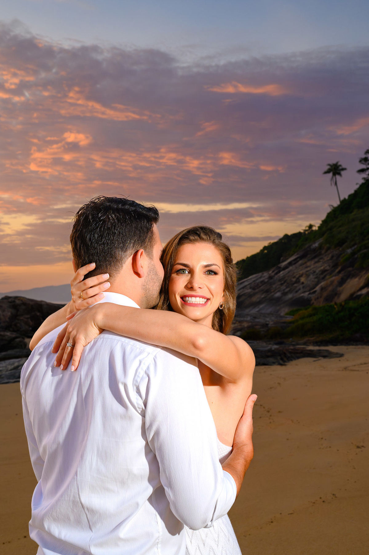 Casal abraçado em frente ao mar ao nascer do sol na Praia do Estaleirinho em Balneário Camboriú – SC