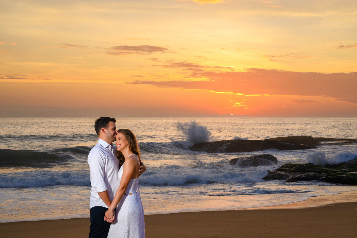 Casal abraçado em frente ao mar ao nascer do sol na Praia do Estaleirinho em Balneário Camboriú – SC