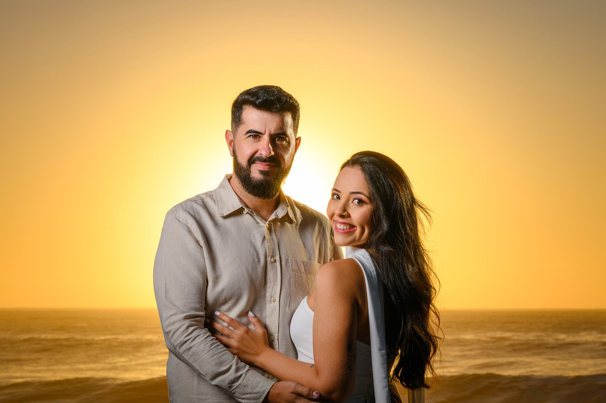 Fotos de casal ao amanhecer em Balneário Camboriú com luz dourada do nascer do sol