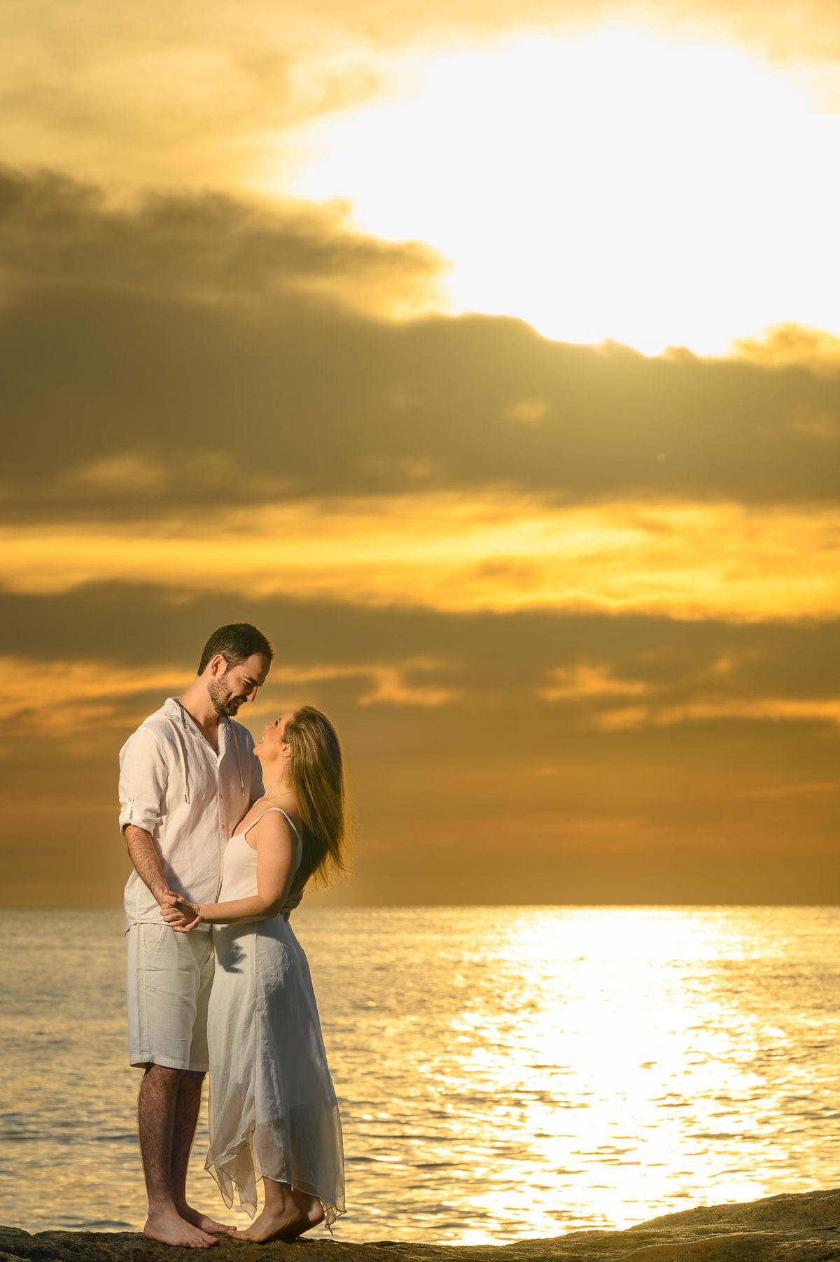 Ensaio de casal na Praia do Estaleirinho com luz de amanhecer e mar ao fundo