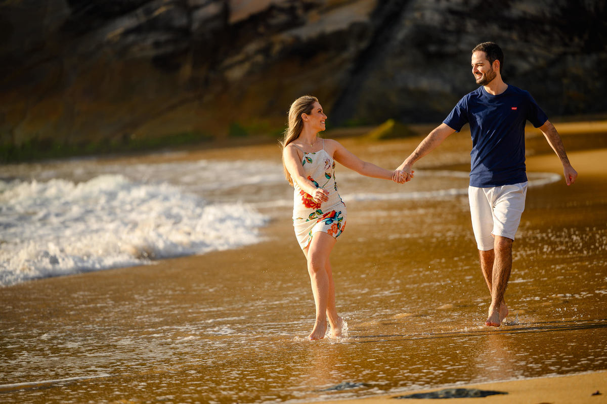 Casal em momento espontâneo no ensaio pré-wedding ao amanhecer na Praia do Estaleirinho