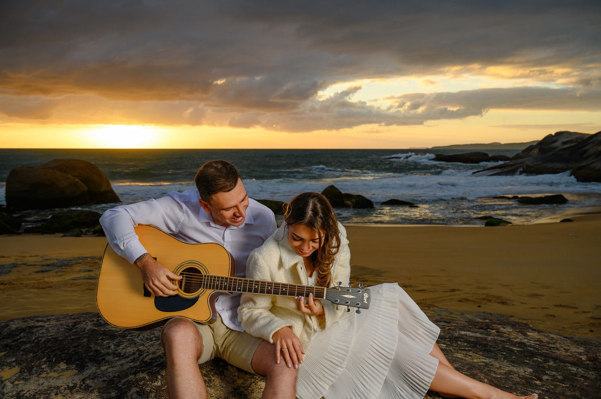 Ensaio fotográfico de casal com violão na Praia do Estaleirinho em Balneário Camboriú SC ao amanhecer