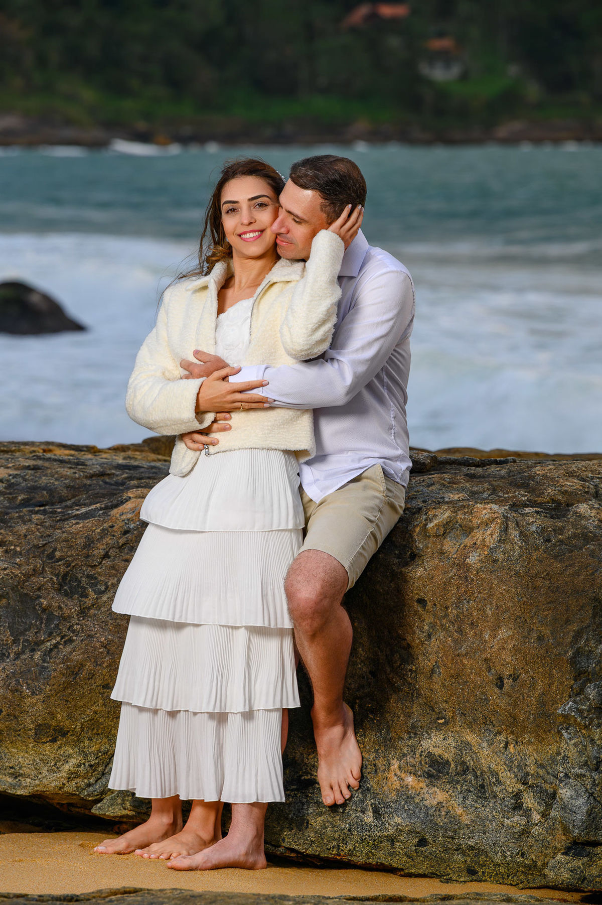 Casal interagindo durante ensaio pré-wedding na Praia do Estaleirinho em Balneário Camboriú SC com mar ao fundo