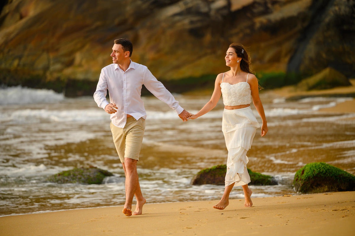 Retrato de casal caminhando lado a lado na praia durante ensaio pré-wedding em Balneário Camboriú SC