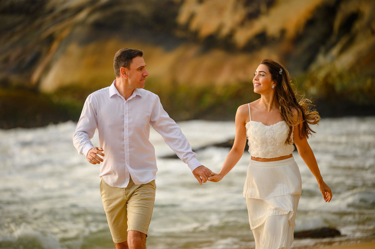 Retrato de casal caminhando lado a lado na praia durante ensaio pré-wedding em Balneário Camboriú SC