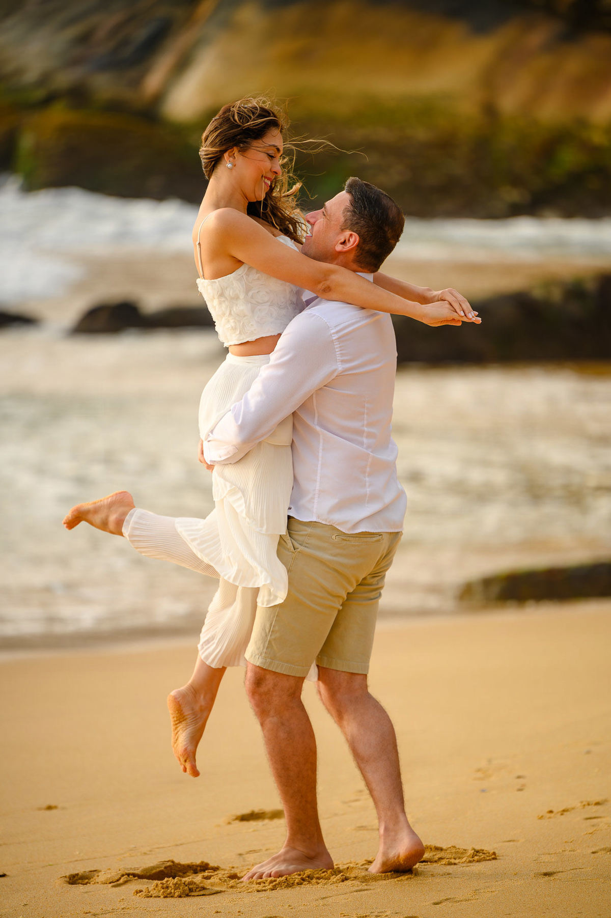 Casal se abraçando com movimento durante ensaio fotográfico de casal na praia em Balneário Camboriú SC