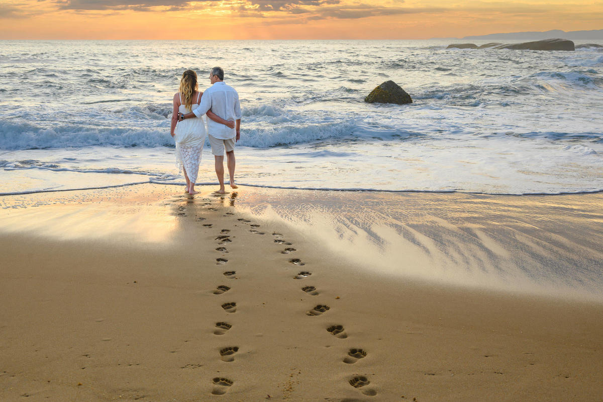 Ensaio fotográfico de pré wedding com casal caminhando na praia em SC