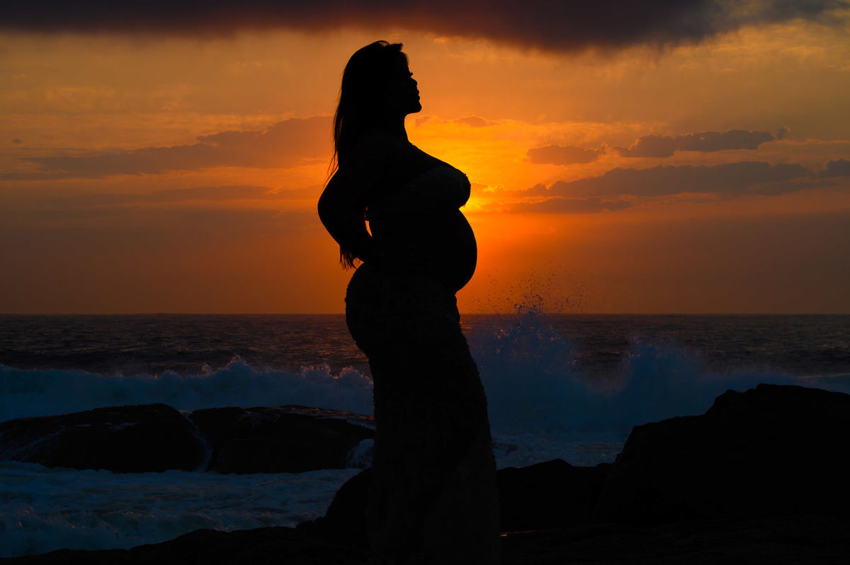 silhueta de gestante bonita durante ensaio fotográfico na praia em santa catarina
