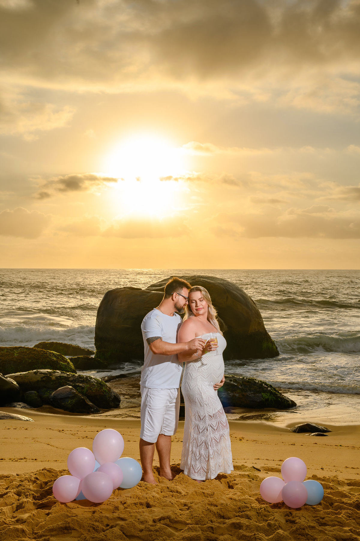 casal celebrando o chá de revelação na praia ao amanhecer em Balneário Camboriú SC