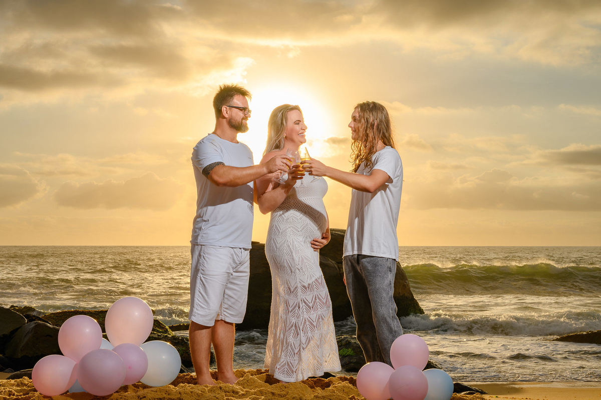 casal celebrando o chá de revelação na praia ao amanhecer em Balneário Camboriú SC