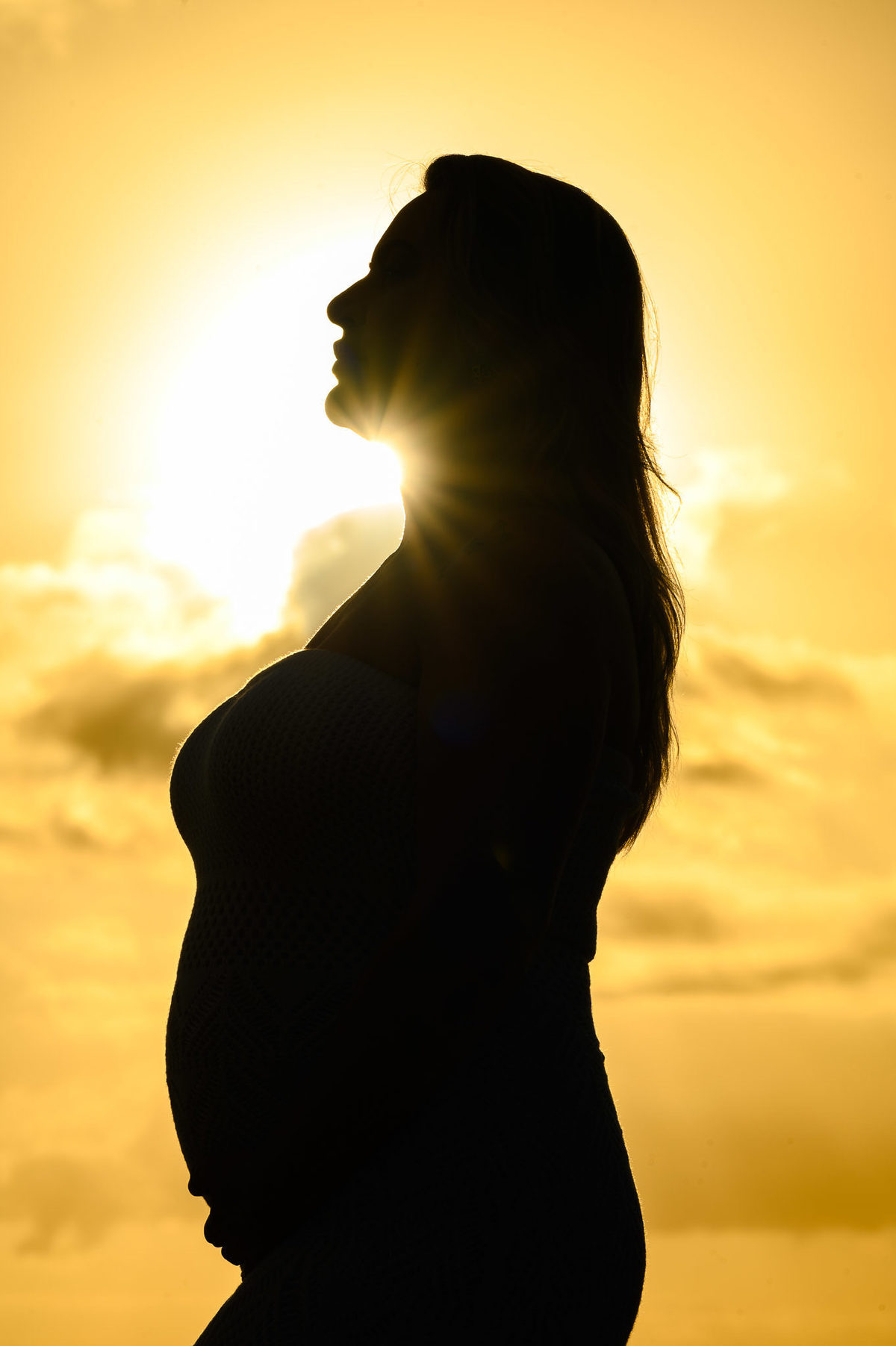 silhueta de gestante ao amanhecer na praia durante ensaio de chá de revelação em Balneário Camboriú SC