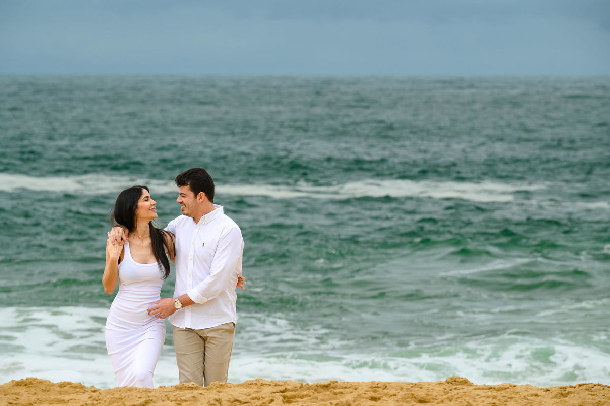 Ensaio gestante na Praia do Estaleirinho em Balneário Camboriú SC com mar verde em dia nublado