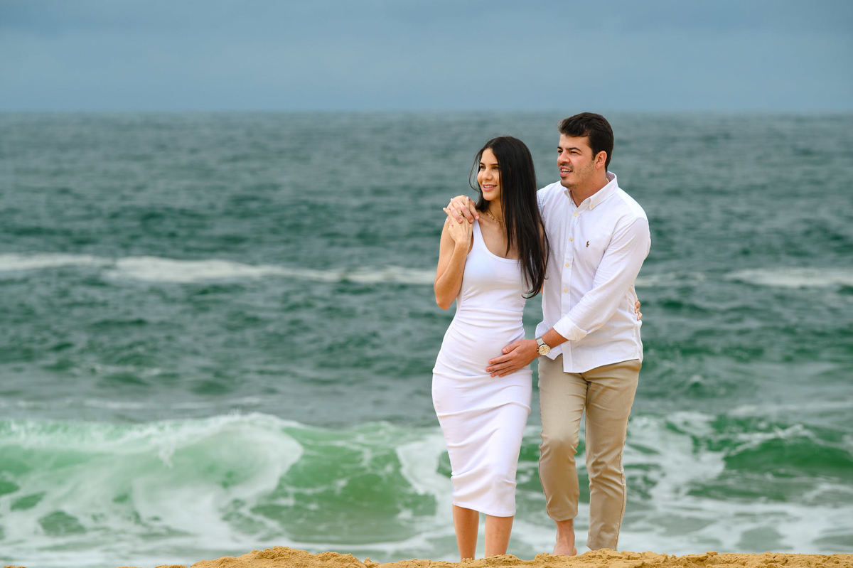 Ensaio gestante na Praia do Estaleirinho em Balneário Camboriú SC com mar verde em dia nubladoFotografia de gestante na praia do Estaleirinho em Balneário Camboriú com céu nublado