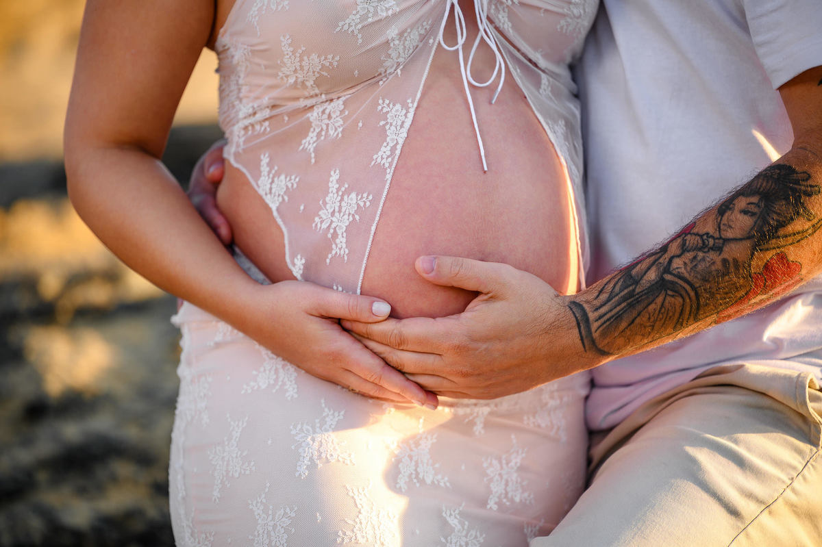 Ensaio gestante na praia em Balneário Camboriú SC com mar ao fundo e luz suave da manhã