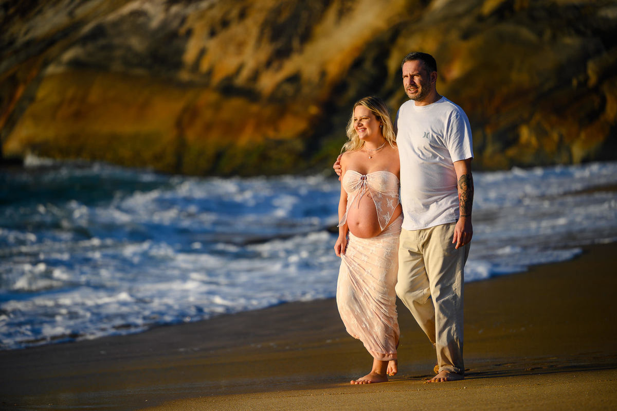 Ensaio gestante na praia em Balneário Camboriú SC com mar ao fundo e luz suave da manhã