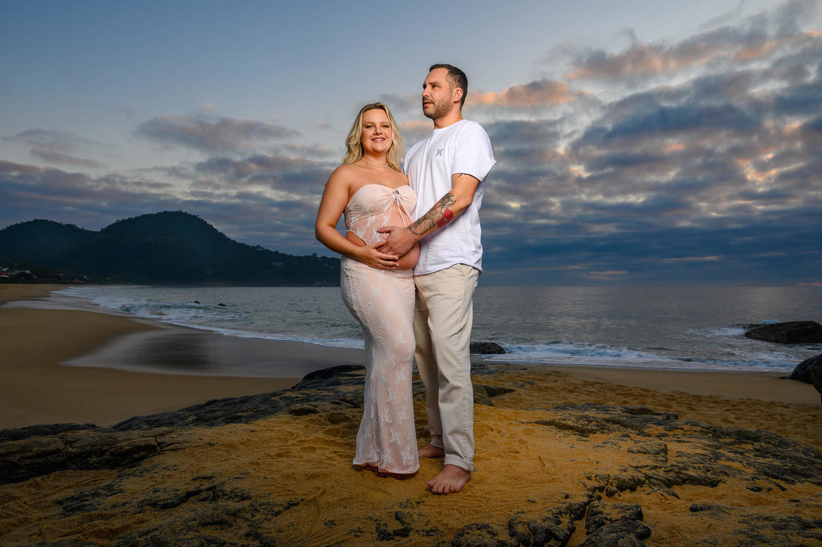 Ensaio gestante na praia em Balneário Camboriú SC com mar ao fundo e luz suave da manhã