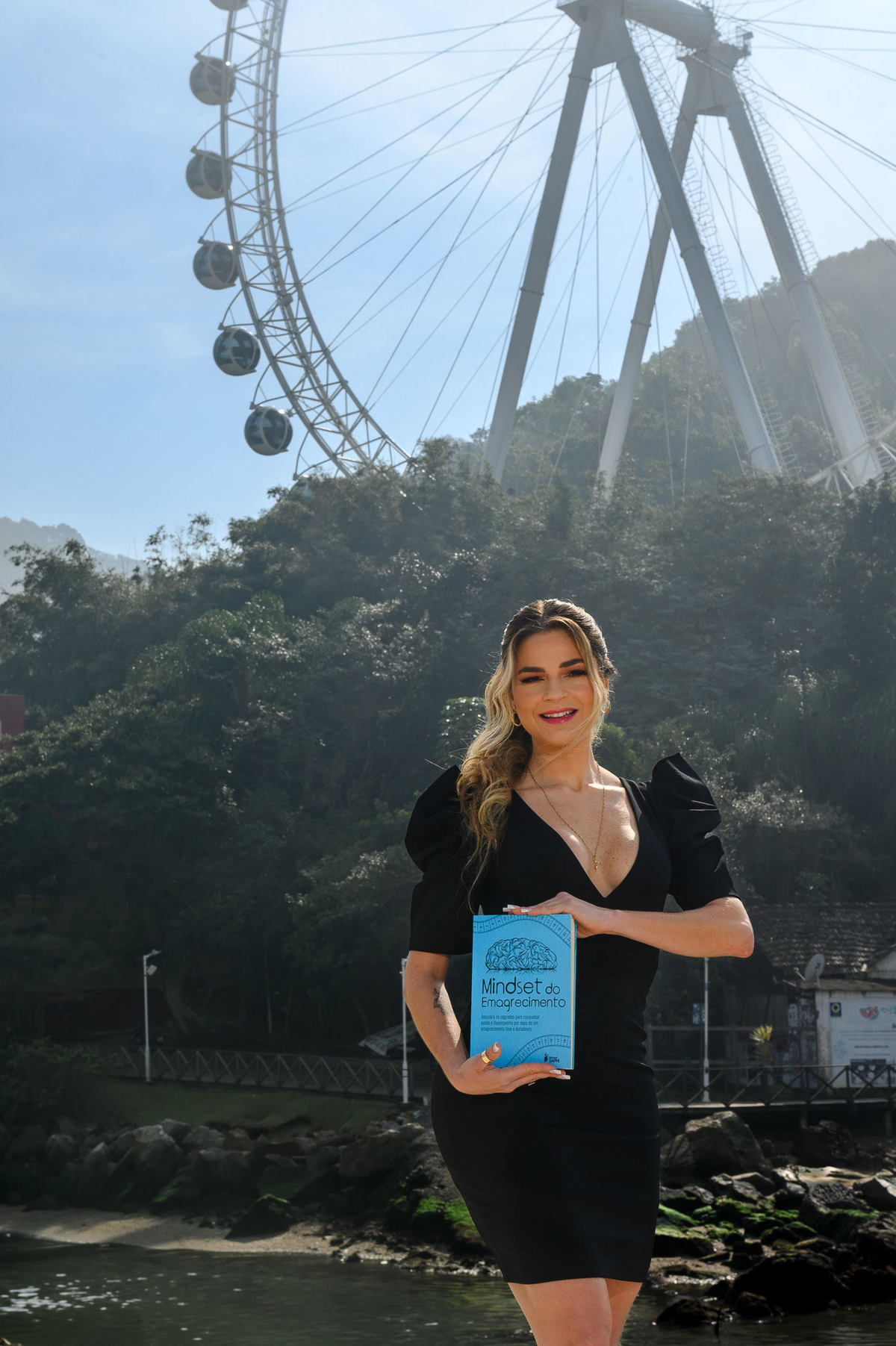 Retrato corporativo feminino em Balneário Camboriú com autora segurando livro sobre emagrecimento