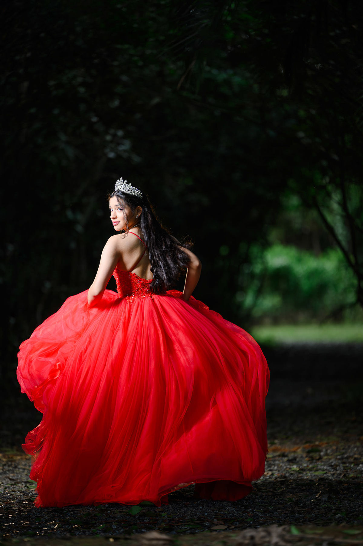 Ensaio fotográfico de 15 anos com vestido vermelho em cenário verde no Parque Raimundo Malta