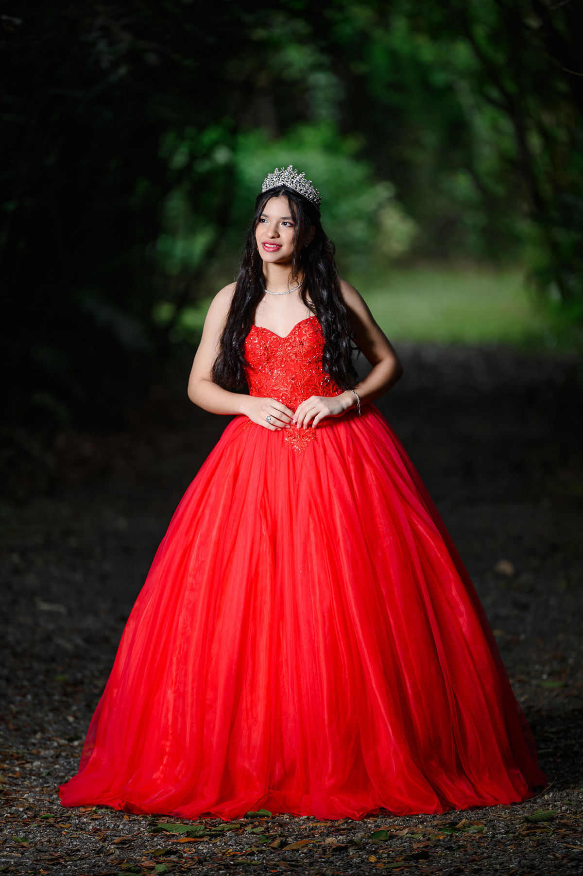 Ensaio fotográfico de 15 anos com vestido vermelho em cenário verde no Parque Raimundo Malta