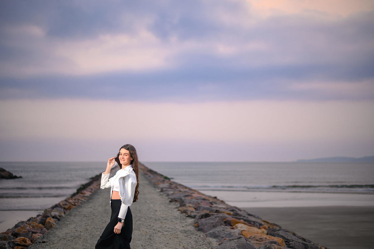Ensaio debutante em Itapema SC no molhe da praia, fotografia de 15 anos com cenário marítimo