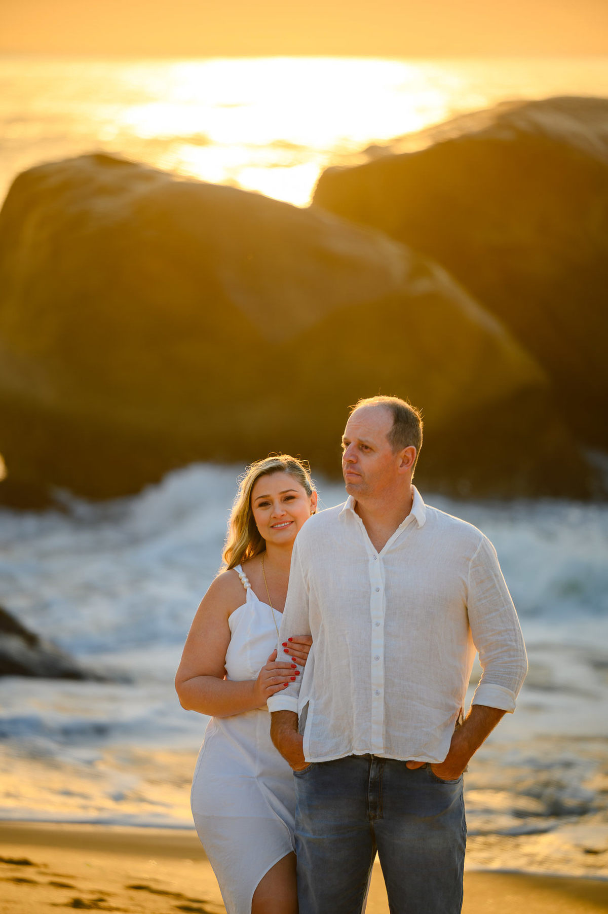 Ensaio de casal na praia de Taquarinhas em Balneário Camboriú com pedras e mar
