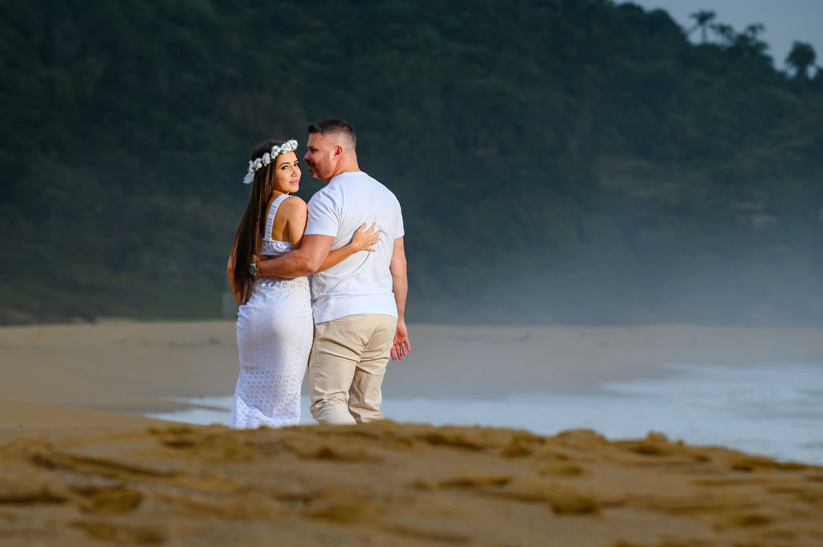 Casal durante ensaio pré-wedding na Praia de Taquarinhas ao amanhecer em Santa Catarina
