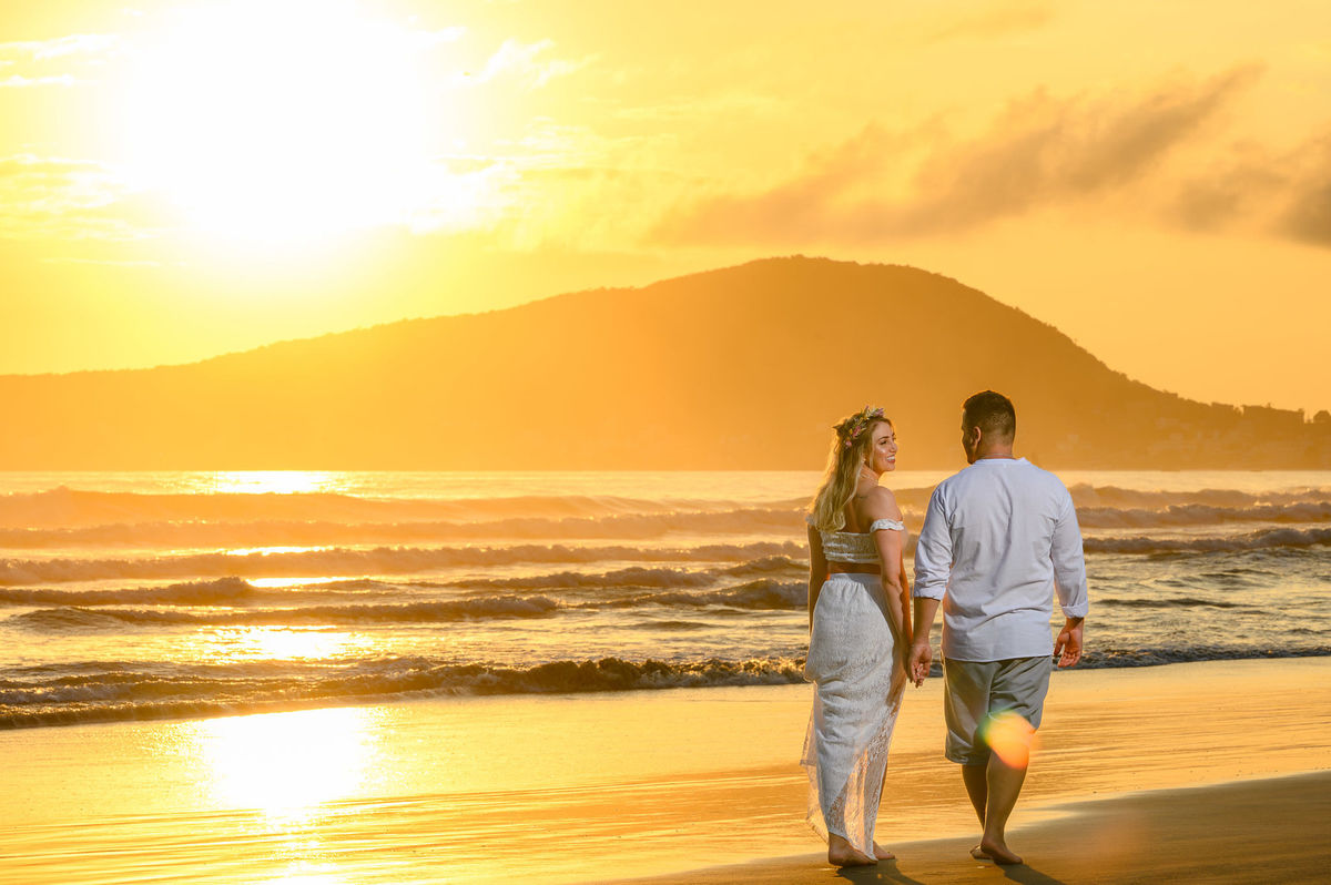 casal andando de costas na beira do mar em bombinhas SC durante ensaio pré wedding