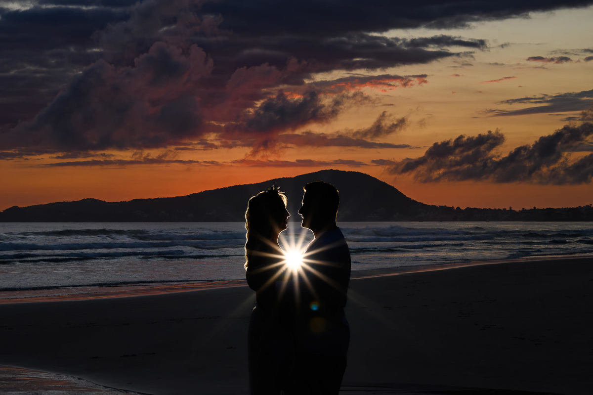 foto artística durante ensaio pré wedding em bombinhas SC com casal em silhueta antes de amanhecer