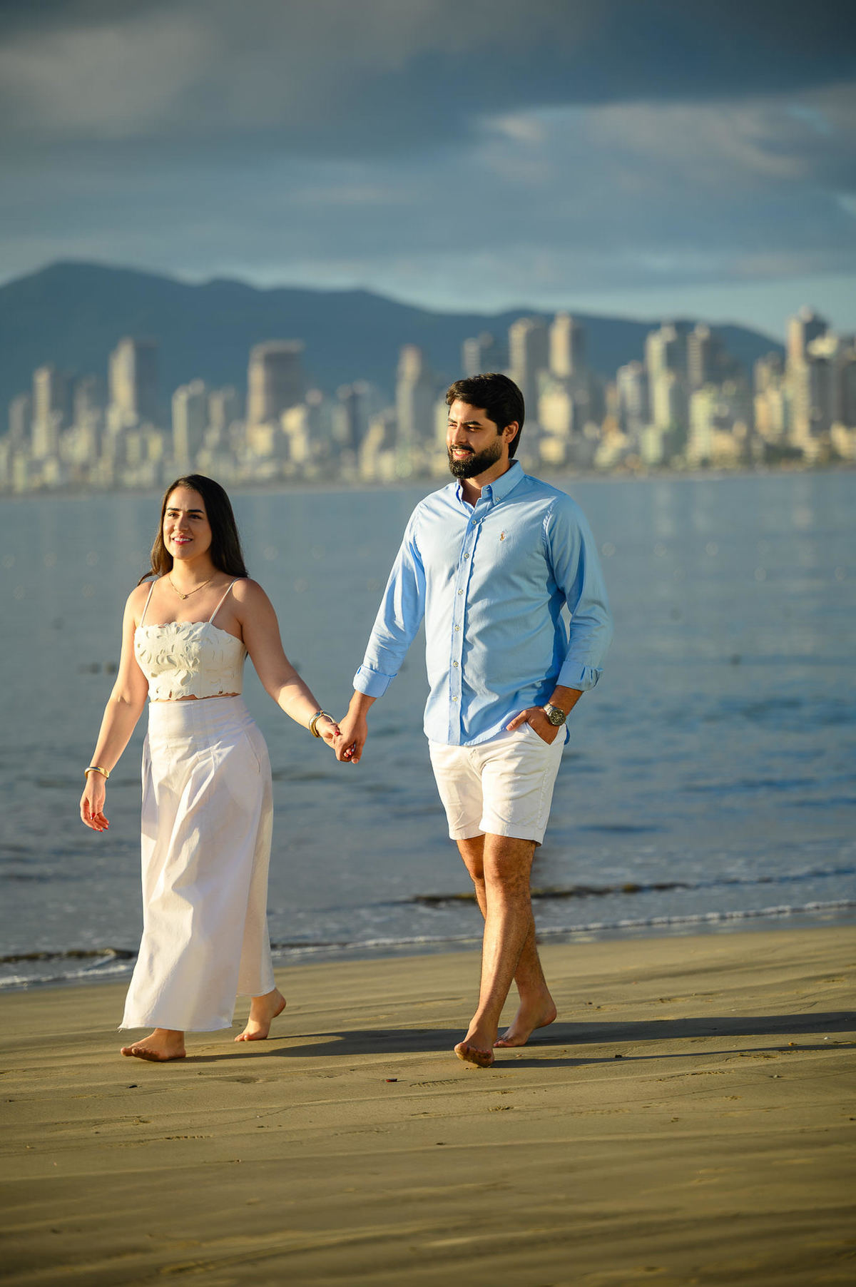 Ensaio fotográfico de casal em Itapema, Santa Catarina, com paisagem urbana ao fundo