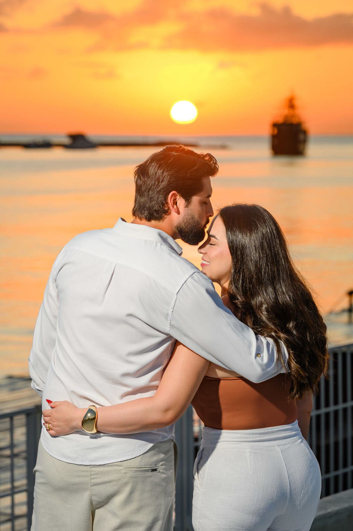 Ensaio de casal no Molhe Norte de Itapema, Santa Catarina, com paisagem litorânea ao fundo