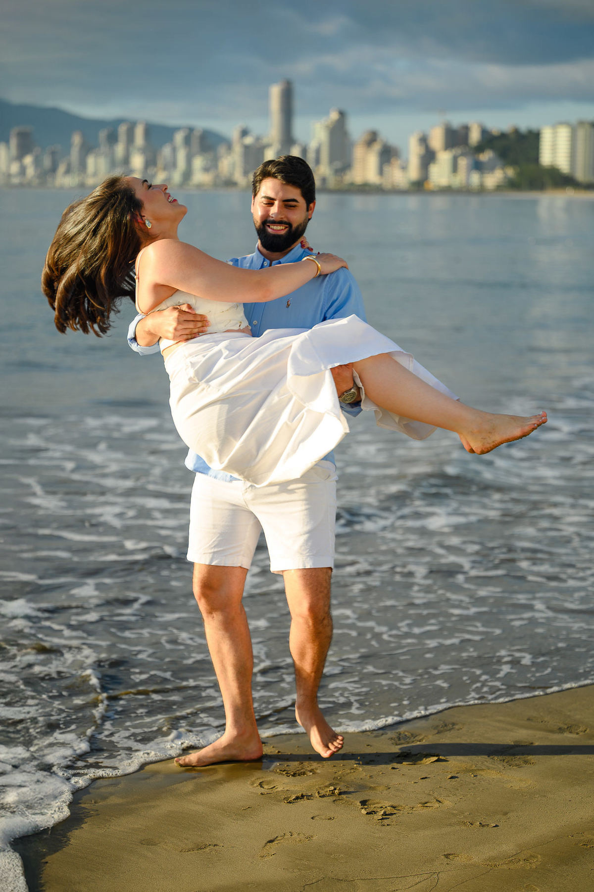 Ensaio fotográfico de casal em Itapema, Santa Catarina, com paisagem urbana ao fundo