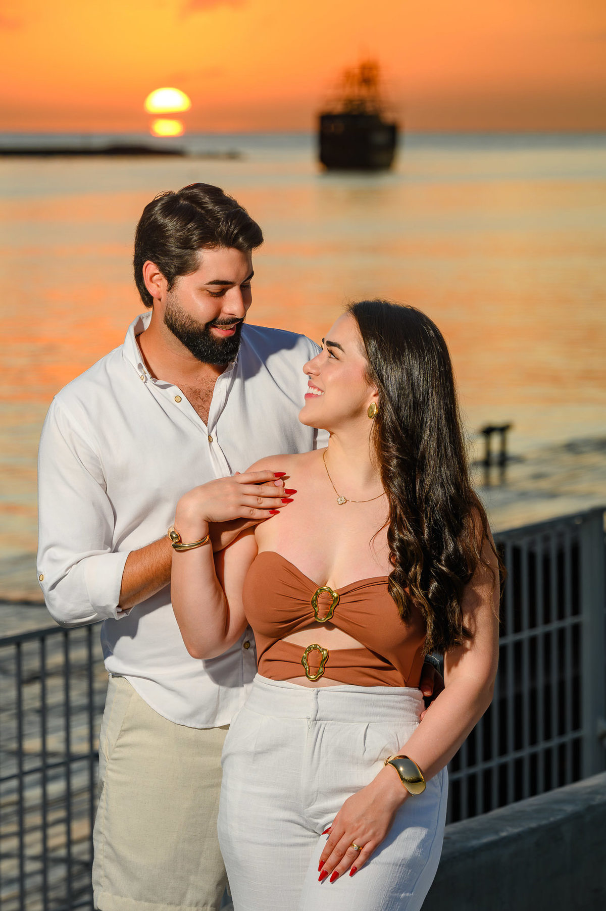 Casal Gabriela e Gabriel em ensaio pré-wedding no Molhe Norte de Itapema, SC, com o mar ao fundo