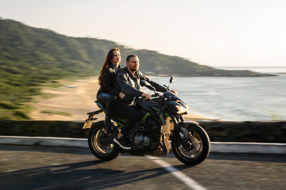 Casal andando de moto em ensaio pré casamento com paisagem litorânea em SC
