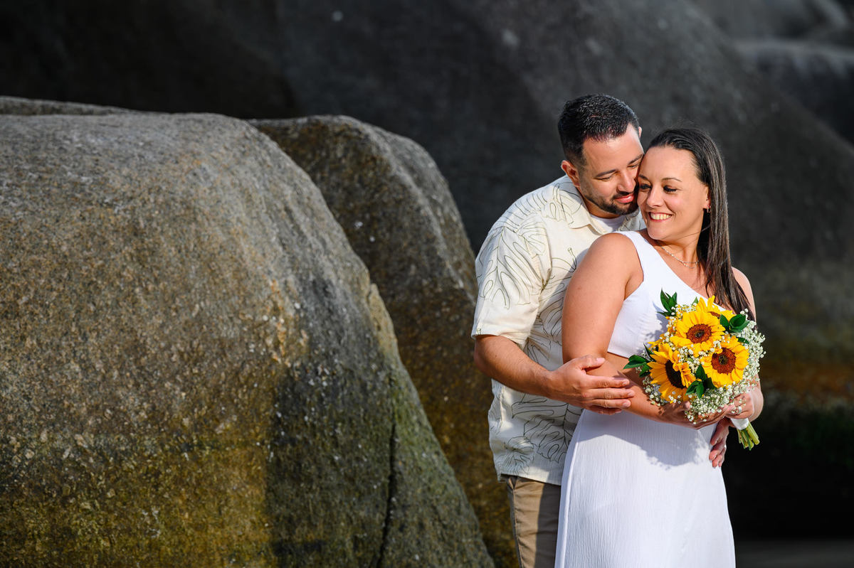 Ensaio de casal em Bombinhas SC com Priscila e Fabiano entre as pedras da praia, fotografia romântica no litoral catarinense