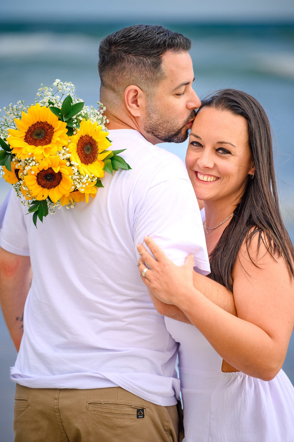 Casal sorrindo durante ensaio fotográfico na praia de Bombinhas SC, fotografia de casal em Santa Catarina