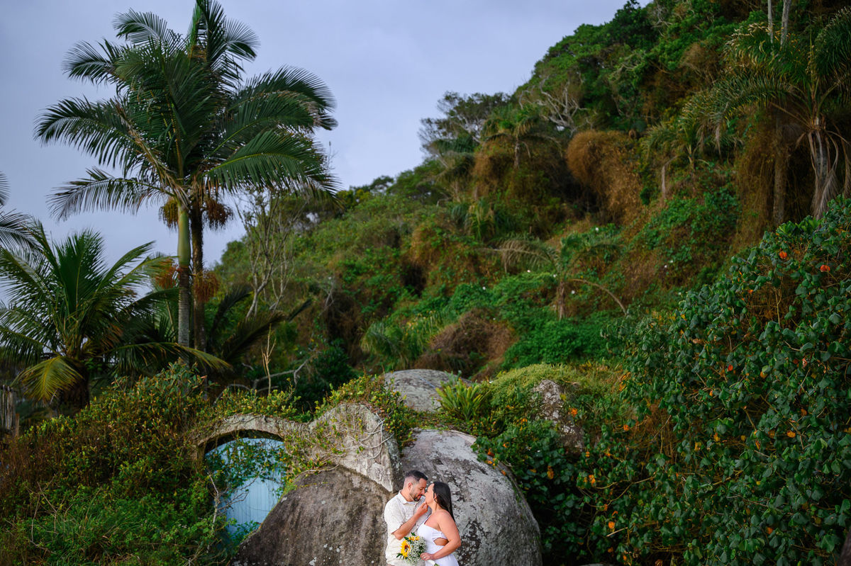 Ensaio de casal em Bombinhas SC com Priscila e Fabiano entre rochas e vegetação, fotografia de casal na praia em Santa Catarina