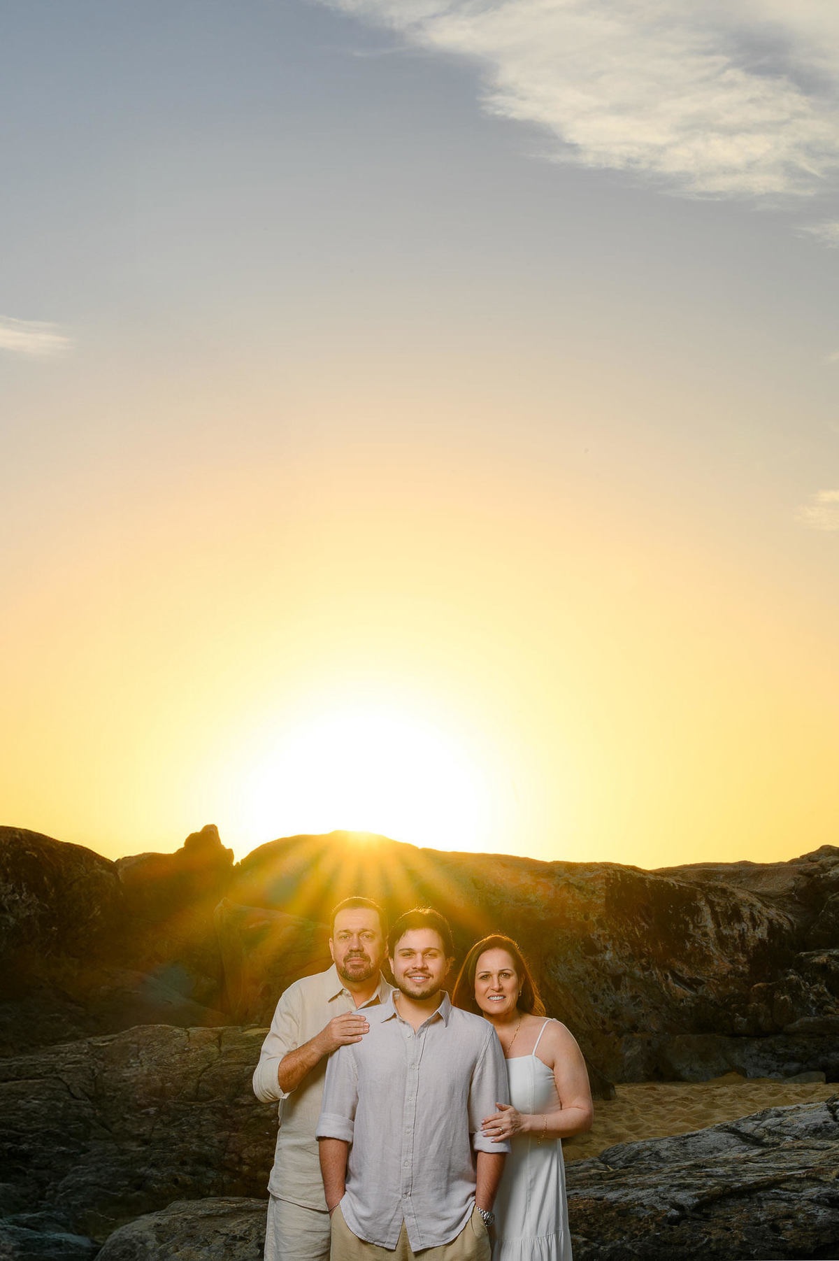 Família sentada nas pedras observando o mar na Praia do Estaleirinho em Balneário Camboriú