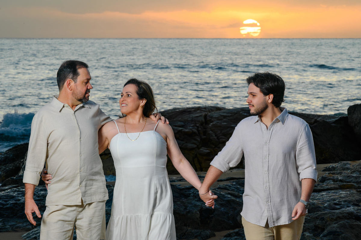 Família caminhando de mãos dadas na Praia do Estaleirinho ao amanhecer em Balneário Camboriú SC
