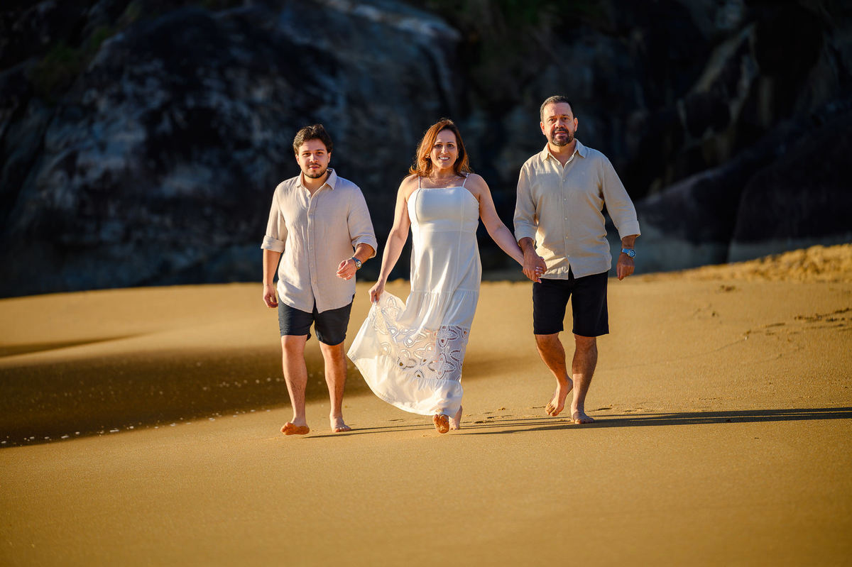Família caminhando de mãos dadas pela Praia do Estaleirinho em Balneário Camboriú Santa Catarina