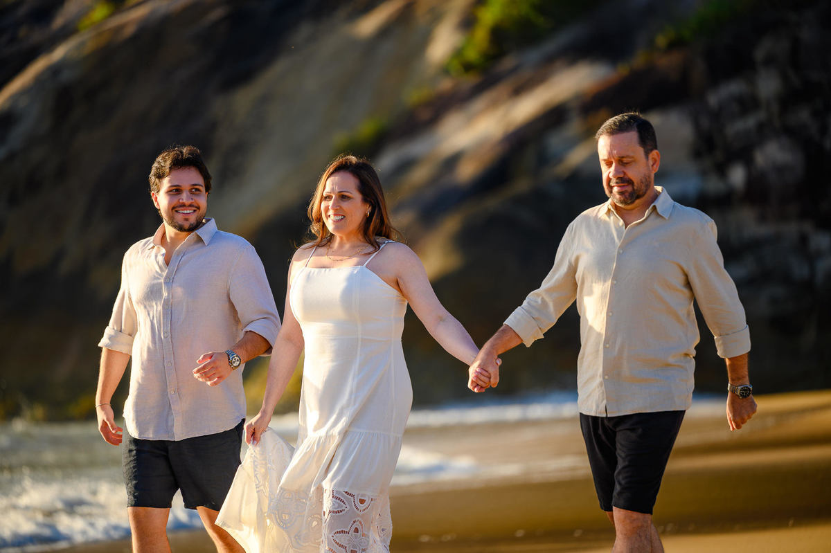 Família caminhando pela areia da Praia do Estaleirinho ao amanhecer em Balneário Camboriú SC