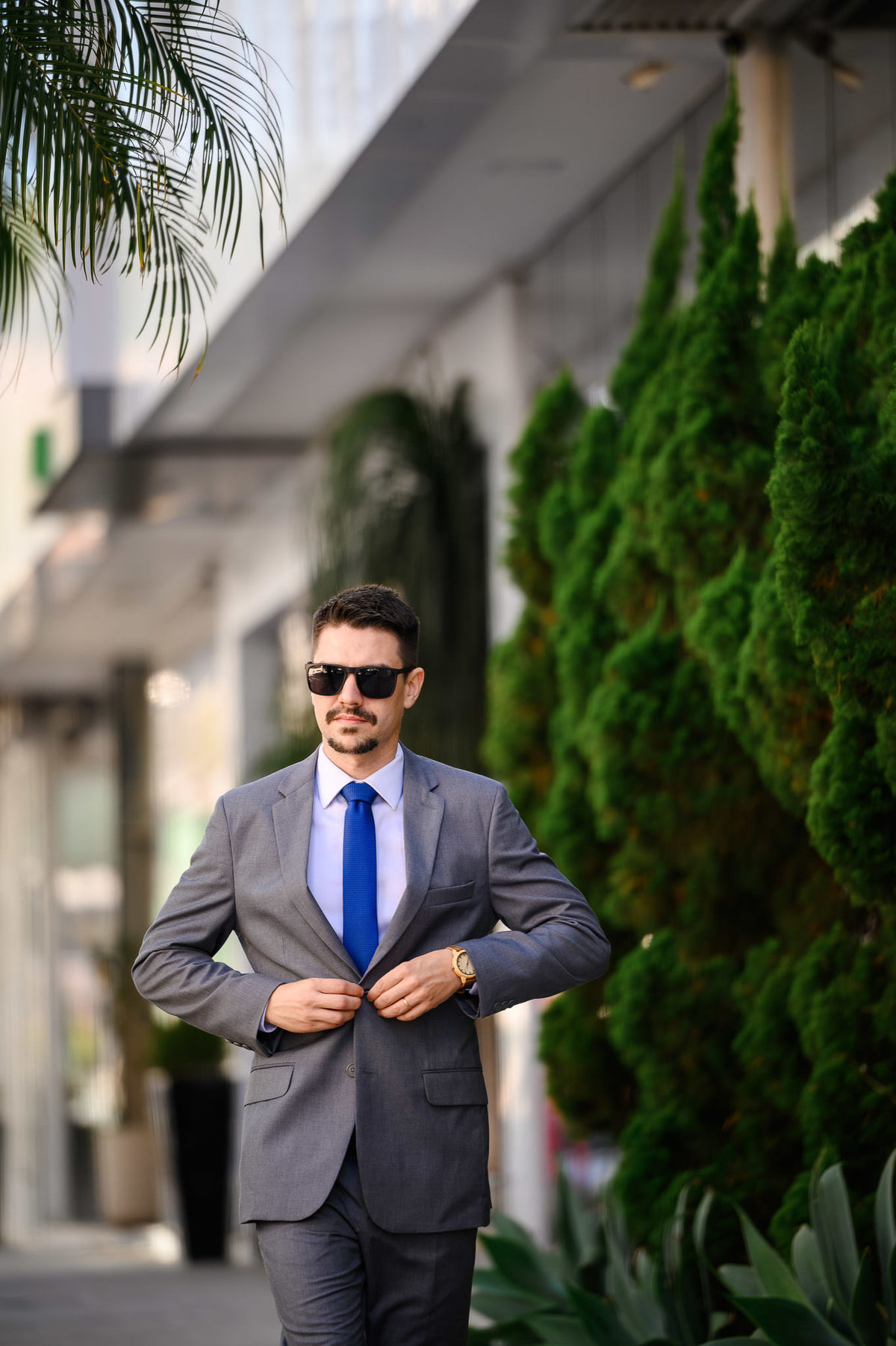 Retrato corporativo profissional de advogado caminhando em ambiente externo com vegetação ao fundo, fotografia de posicionamento profissional em Balneário Camboriú.